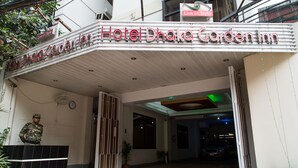 La entrada del Hotel Dhaka Garden Inn, con un camino empedrado que conduce al interior.