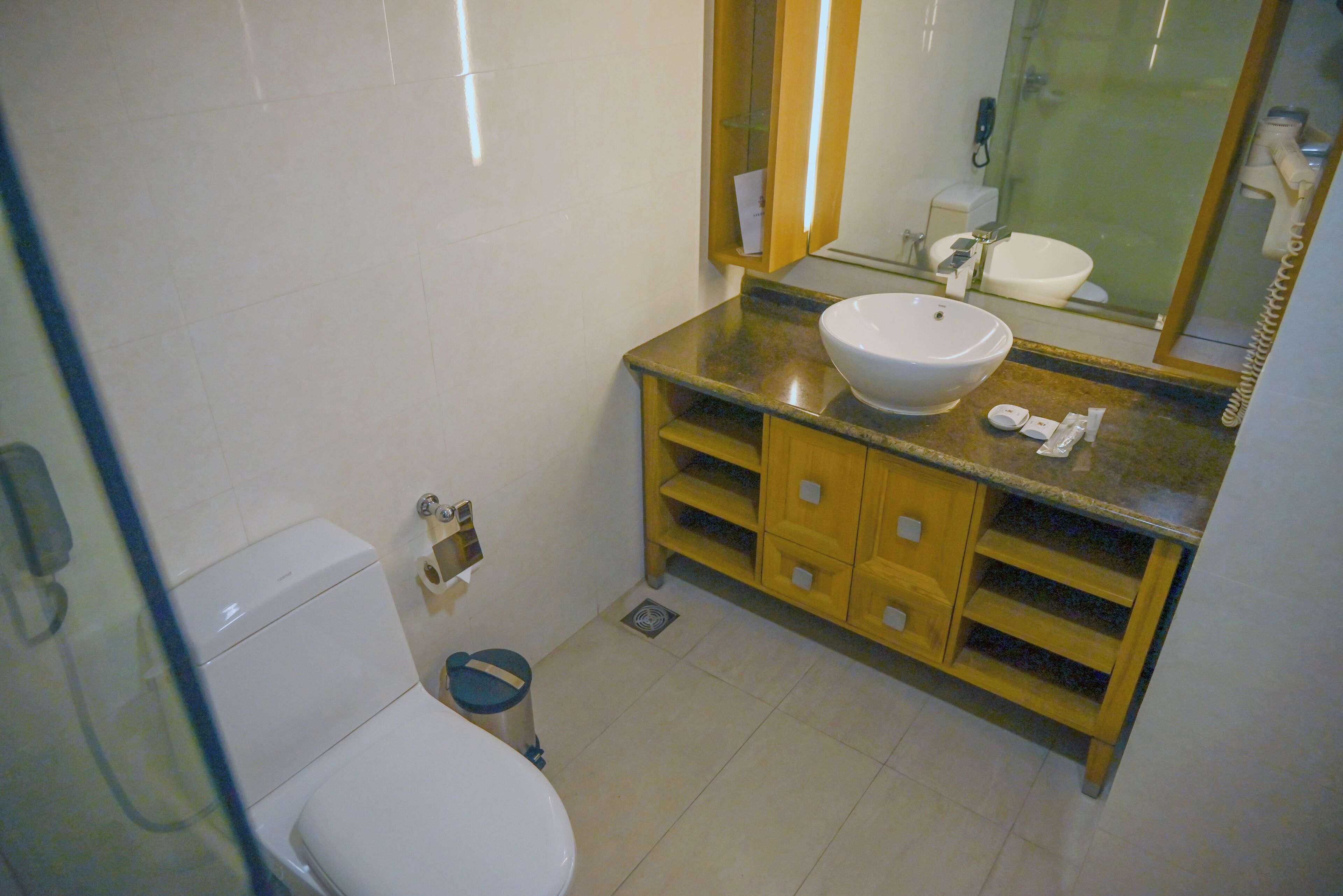A bathroom with a white toilet, a sink, and a mirror.