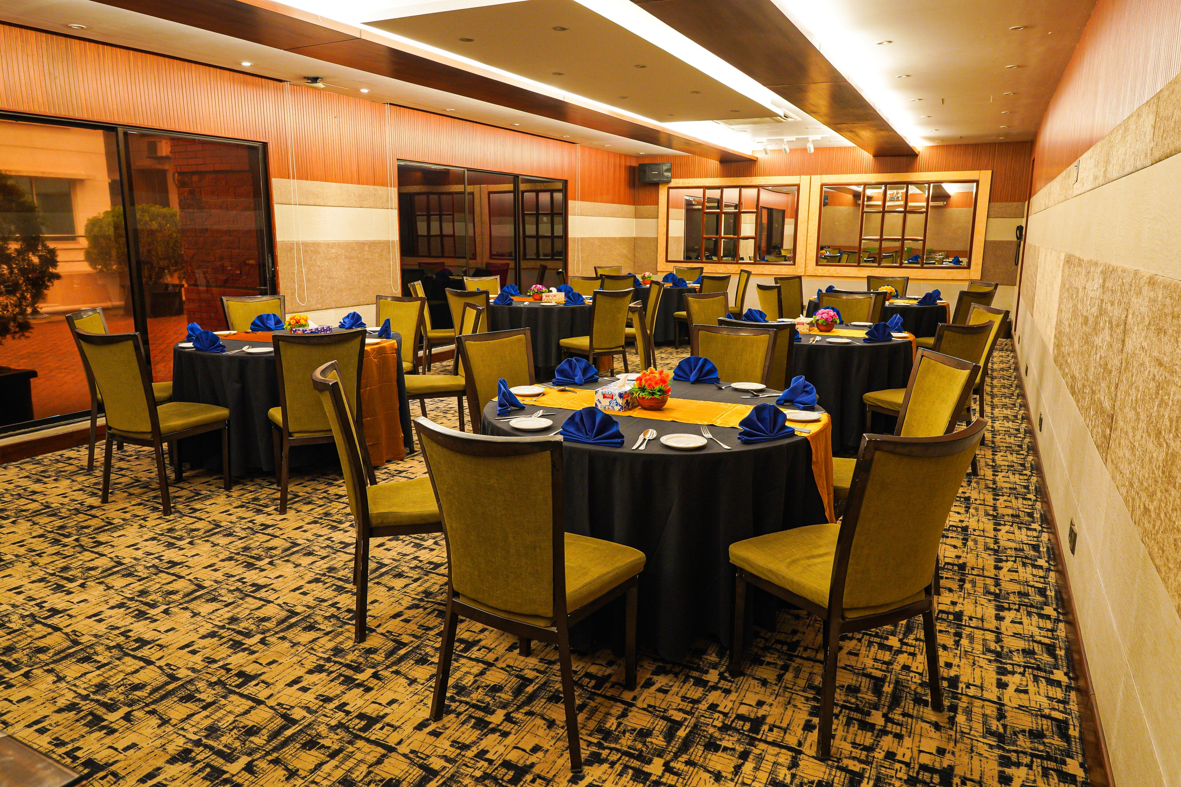 A conference room with multiple tables and chairs, equipped with nameplates and table settings.