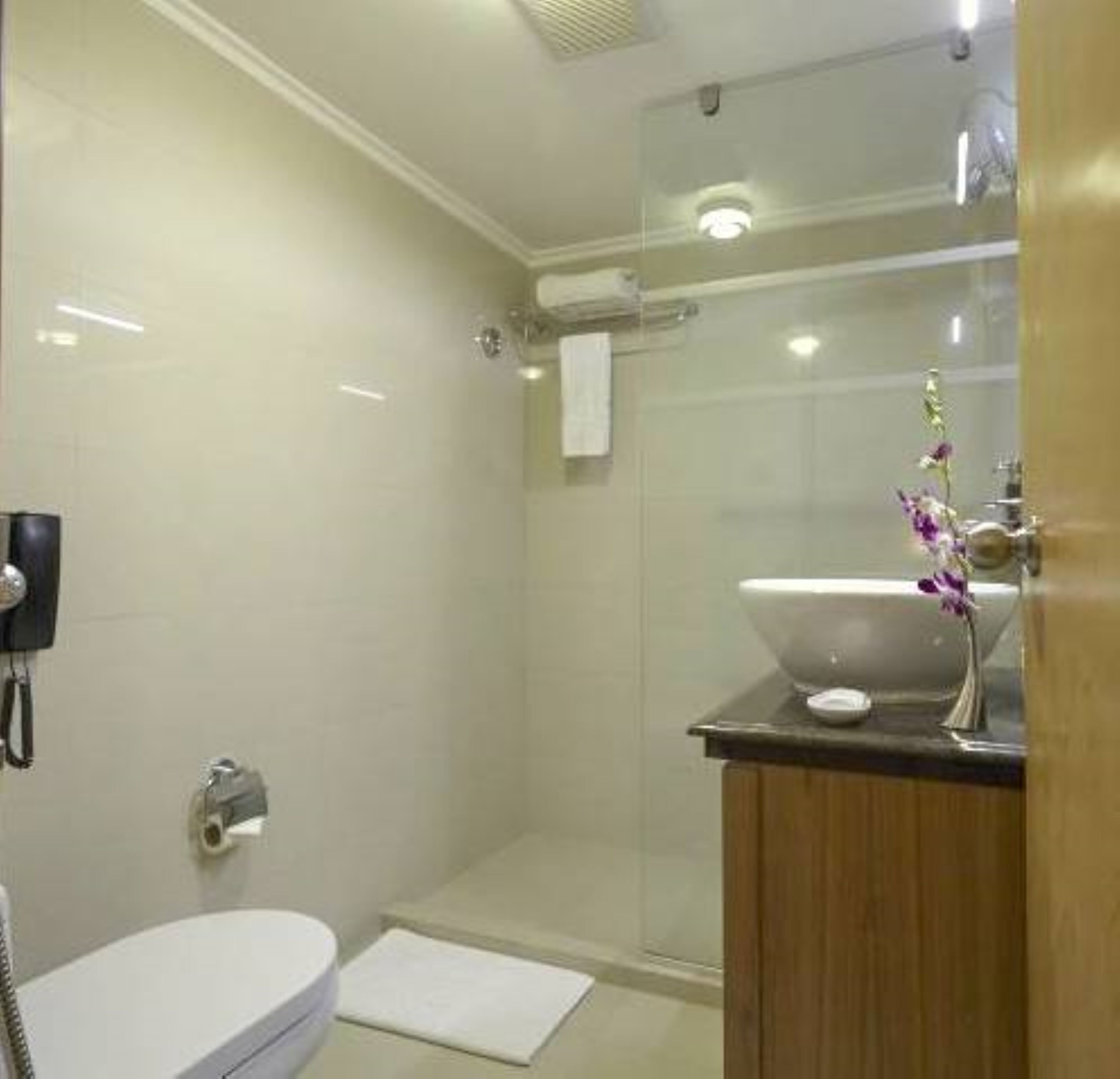 Un baño moderno con inodoro, lavamanos y zona de ducha.