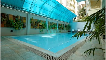 Una piscina al aire libre, sillones reclinables de piscina