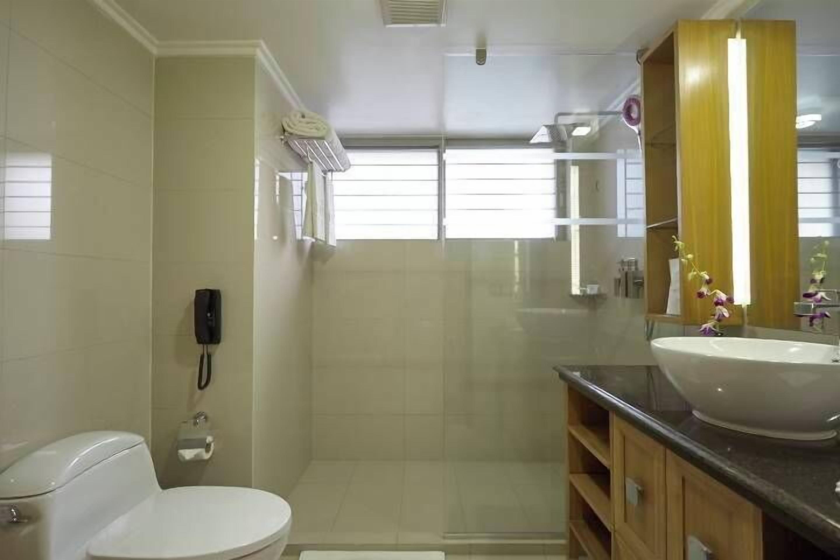 A modern bathroom with a toilet, shower, and sink.