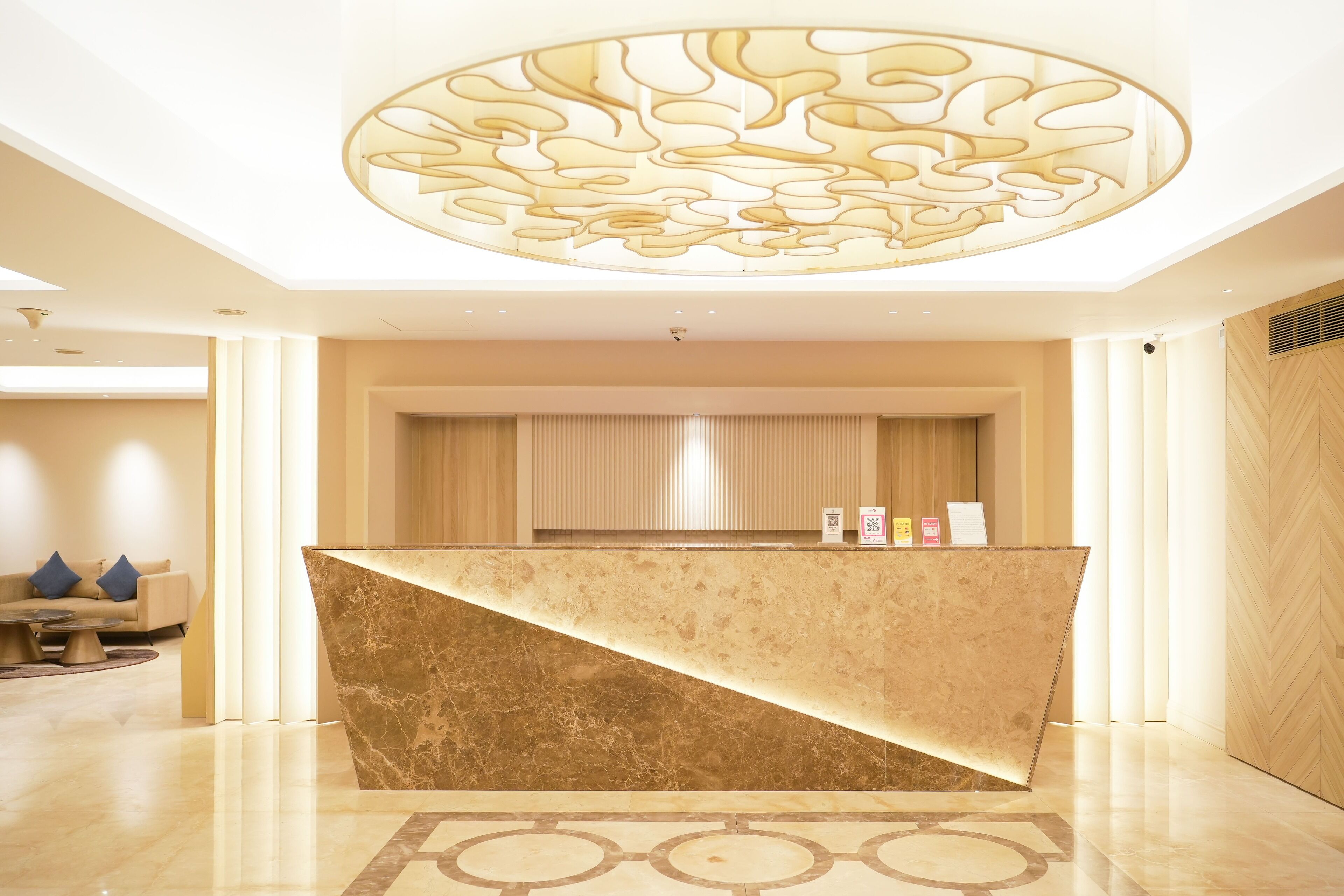 Una recepción con mostrador de mármol, techo decorativo y diseño de interiores moderno.