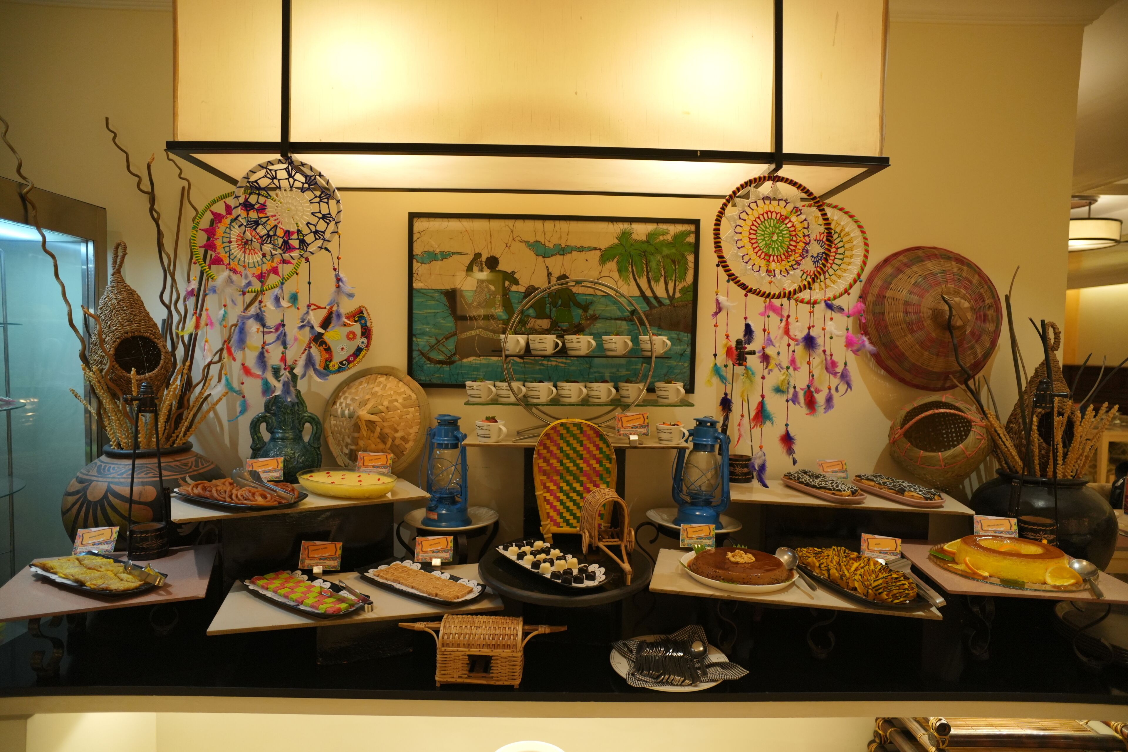 Un buffet proposant une variété de plats et agrémenté de décorations, notamment des attrape-rêves.