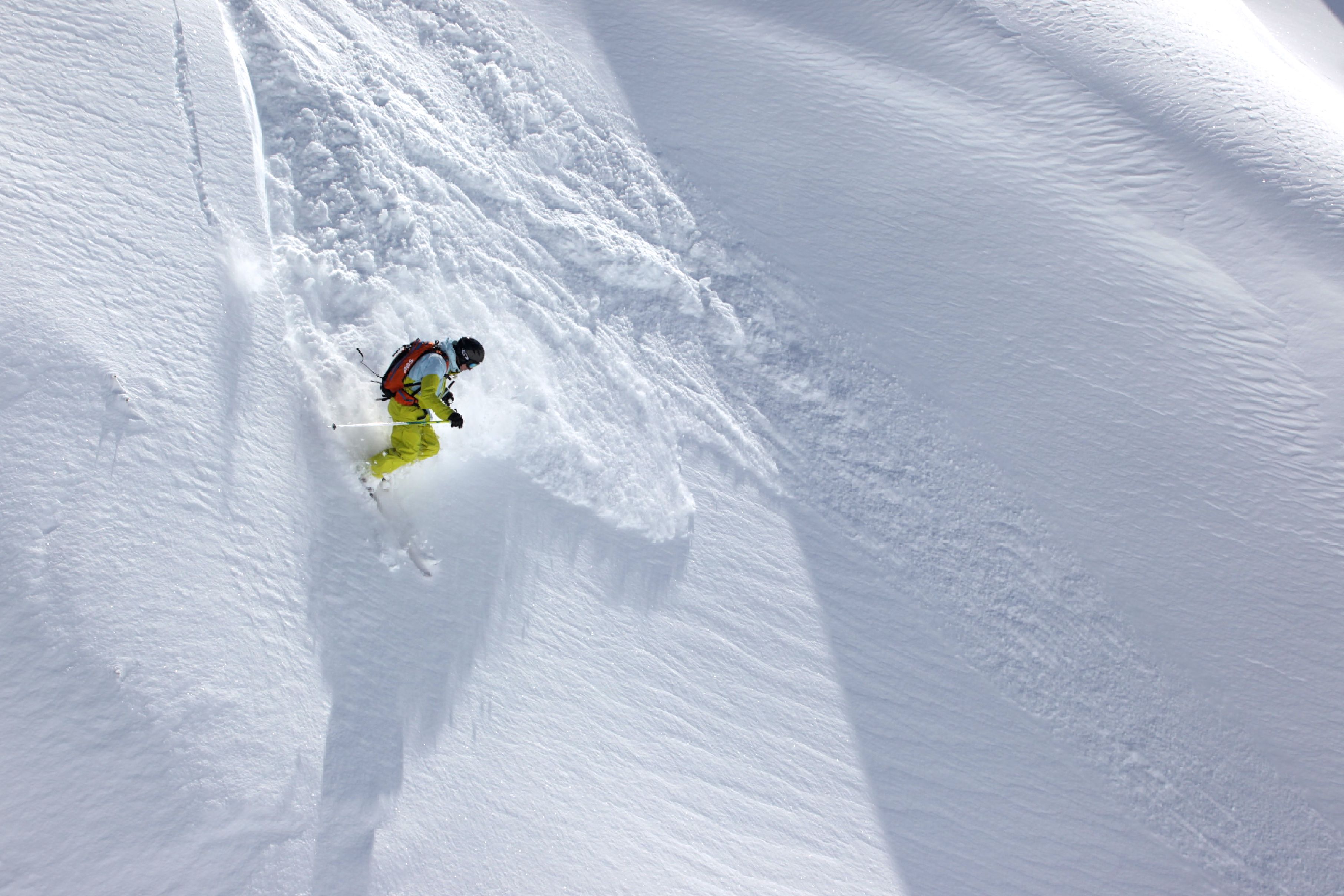 A snowy slope with a skier.