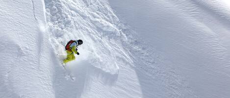 A snowy slope with a skier.