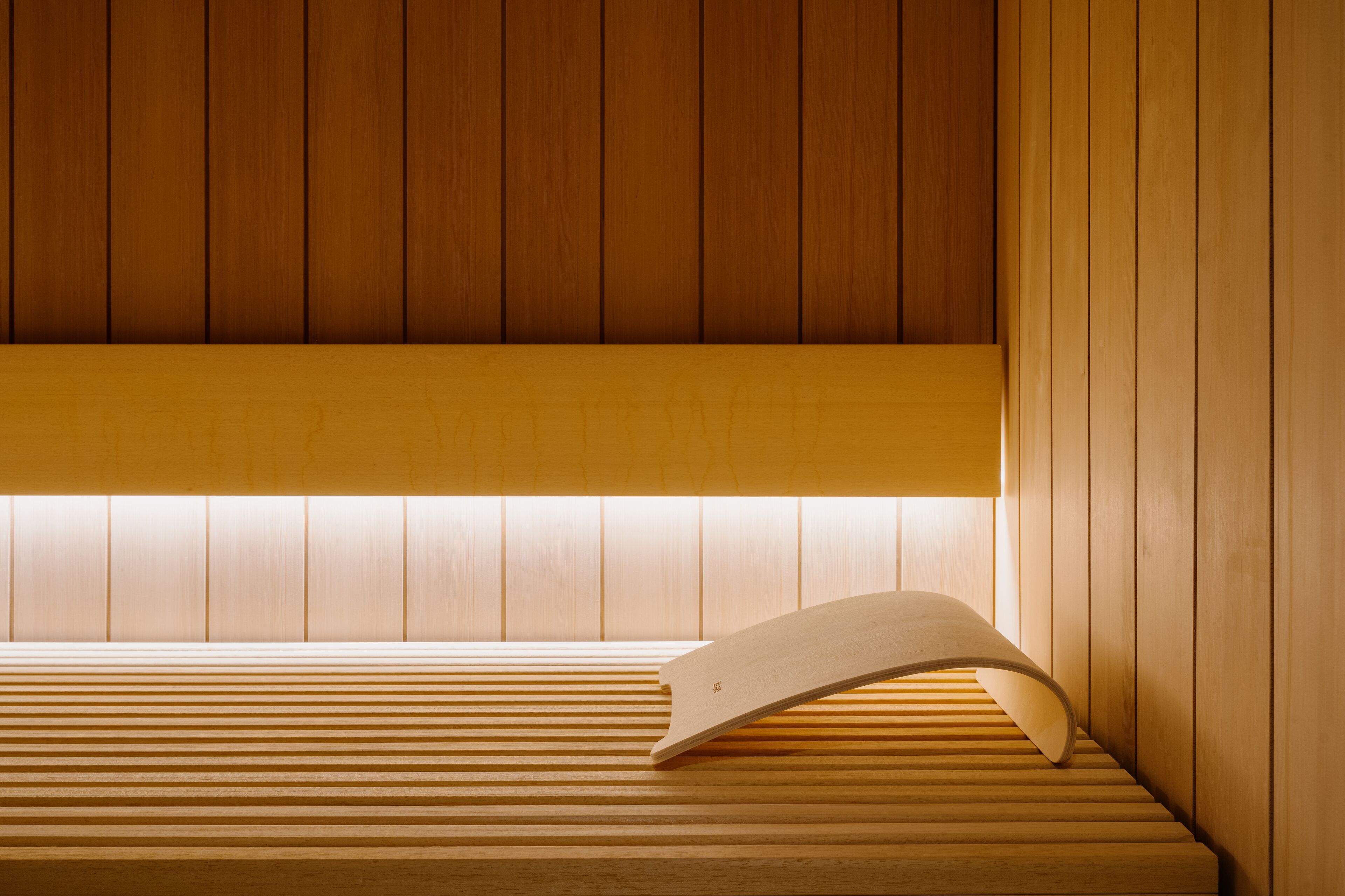 A wooden bench with a slatted design and a curved backrest.