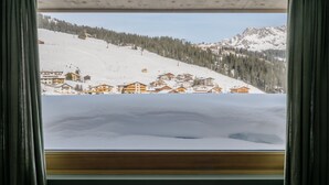 A view of a snow-covered mountain with wooden chalets and a clear sky. - Appart Hotel Knappaboda (Lech am Arlberg)