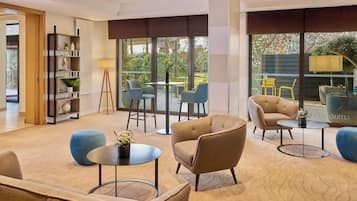 Un salon moderne comprenant un canapé, des fauteuils, une table basse et une bibliothèque.