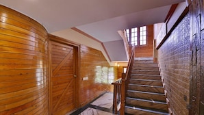 A wooden interior with a staircase leading to an upper level. - The Woodstock Resort (Shimla)