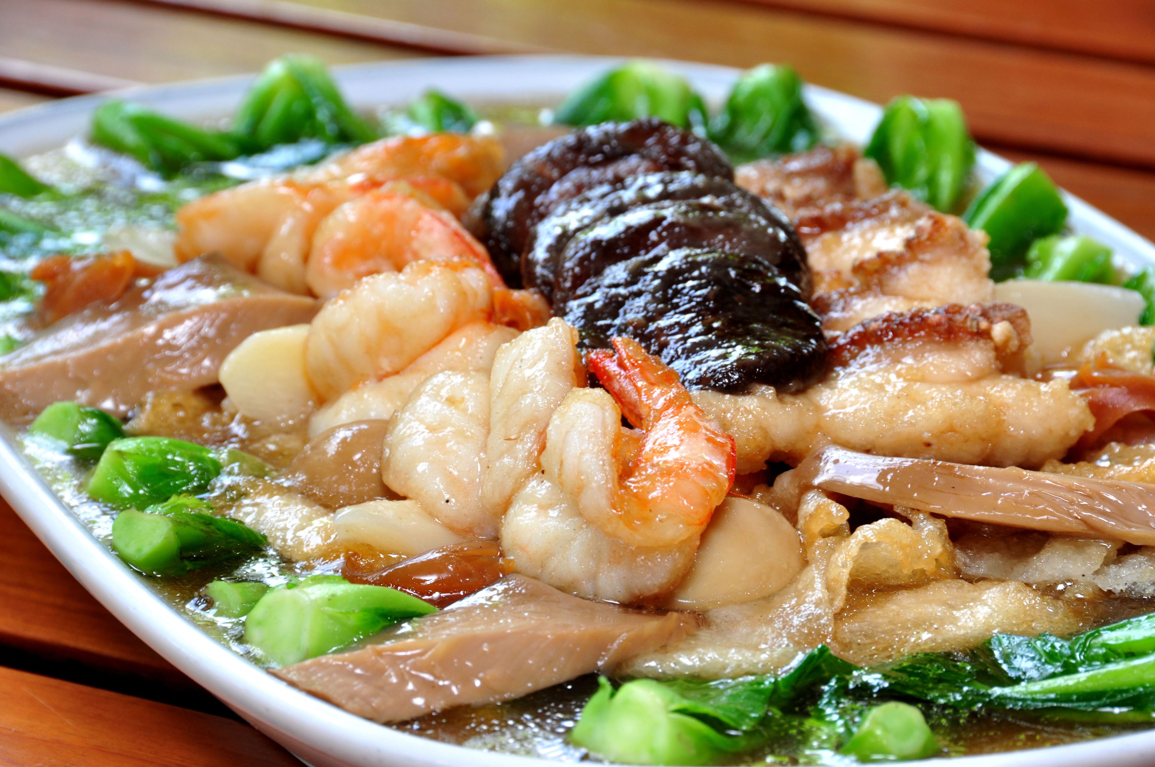 A plate of seafood with shrimp, squid, and vegetables.