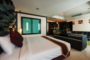 A modern hotel room with a large bed, a desk, and a TV.
