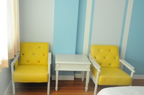 A room with two yellow armchairs and a small white table.