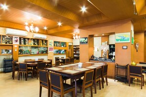A restaurant with wooden tables and chairs, a bar area, and various decorations on the walls.