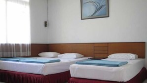 Ett hotellrum med två sängar, båda med vita sängkläder och en blå detaljfärg.
