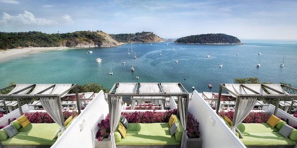 Enjoy a panoramic ocean view from this seaside terrace with comfortable seating areas and lush surroundings.