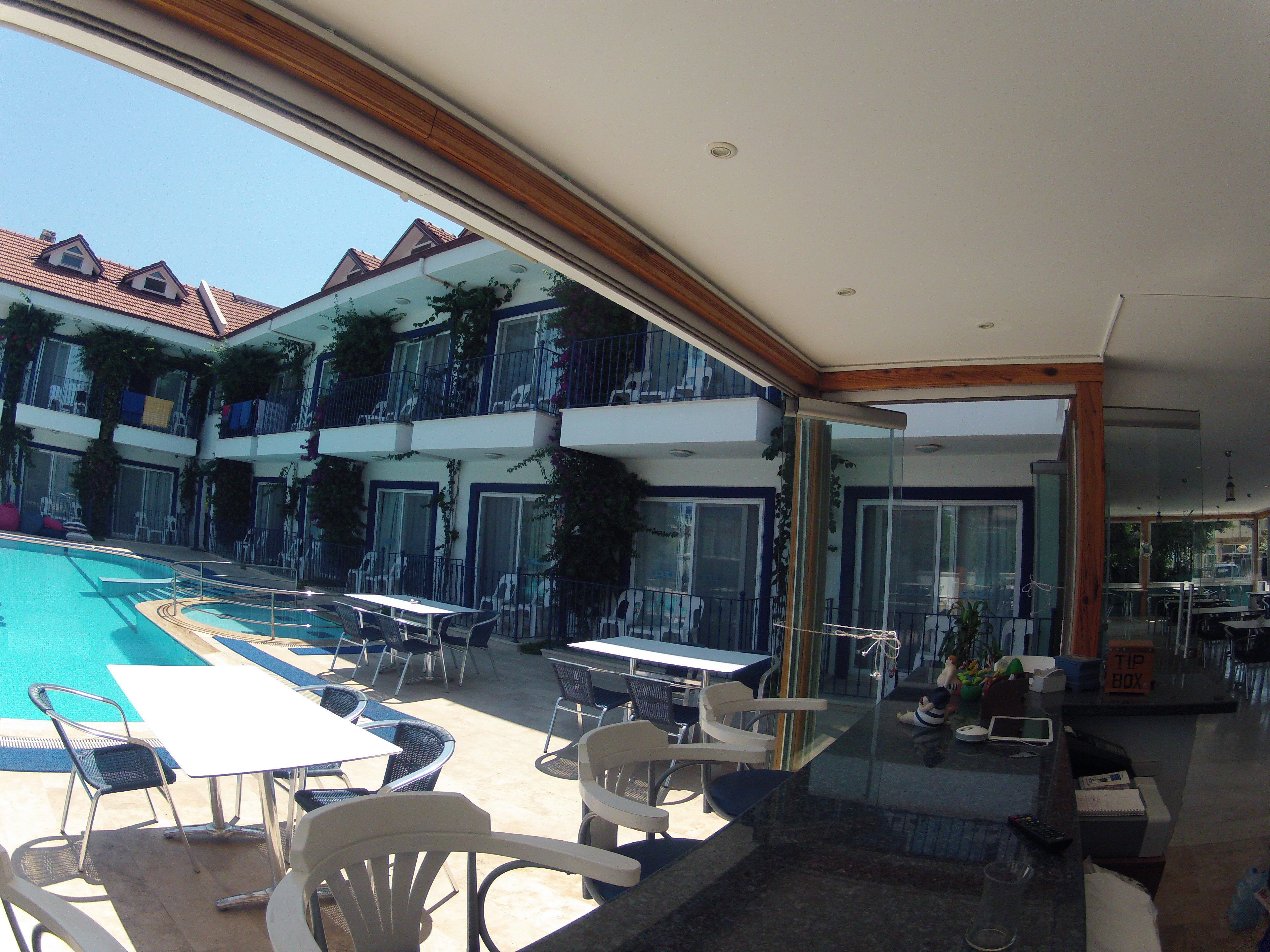 A poolside area with outdoor seating and a view of a multi-story building with balconies.