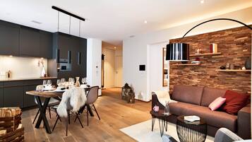 Un espace de vie moderne comprenant un coin repas, un canapé et un mur d’accent en bois.