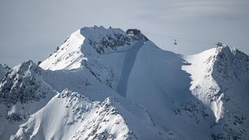 A snow-covered mountain with a ski lift and a cable car system.