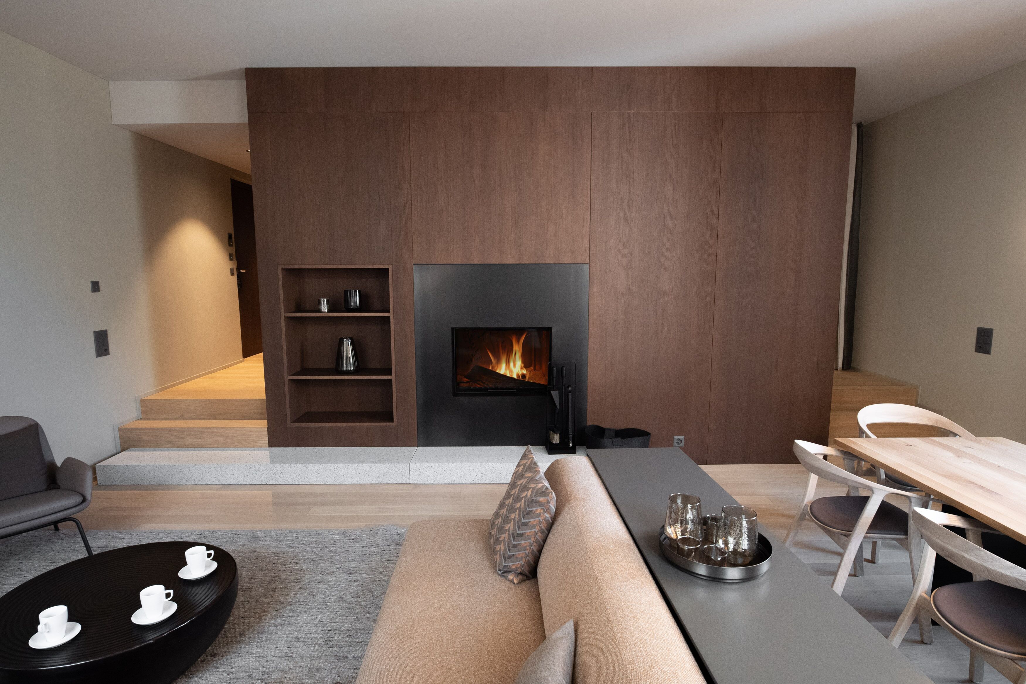 Un salon moderne avec une cheminée, un canapé, une table à manger et une table basse.