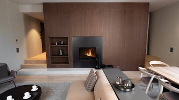 Un salon moderne avec une cheminée, un canapé, une table à manger et une table basse.
