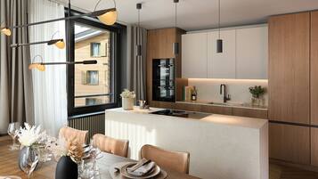 A modern kitchen with a central island, a dining area with a table set for two, and a large window with curtains.