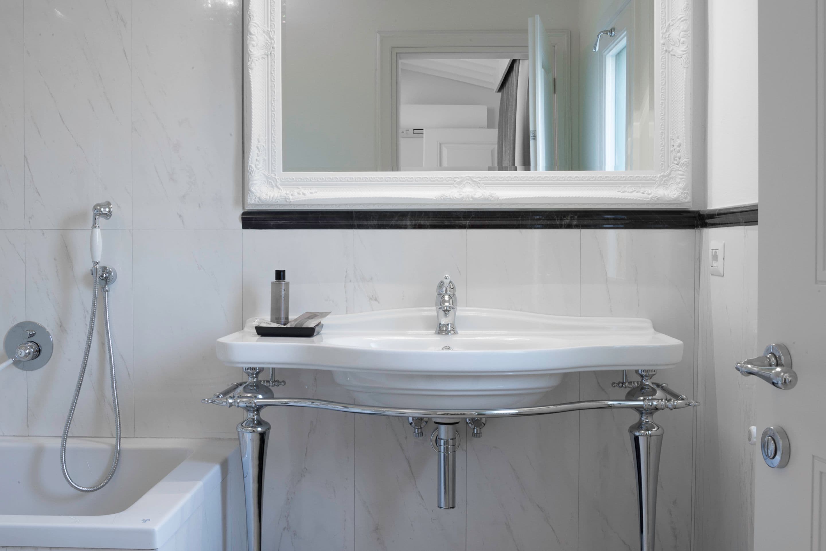 A bathroom with a white sink, a mirror, and a shower.