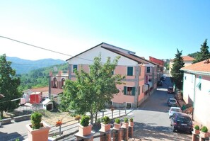 A residential street with houses, a clear sky, and a mountain in the background. - Albergo La Veranda (Maissana)