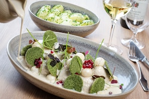 A dining table with a bowl of potato salad and a glass of white wine. - Malling Kro (Malling)