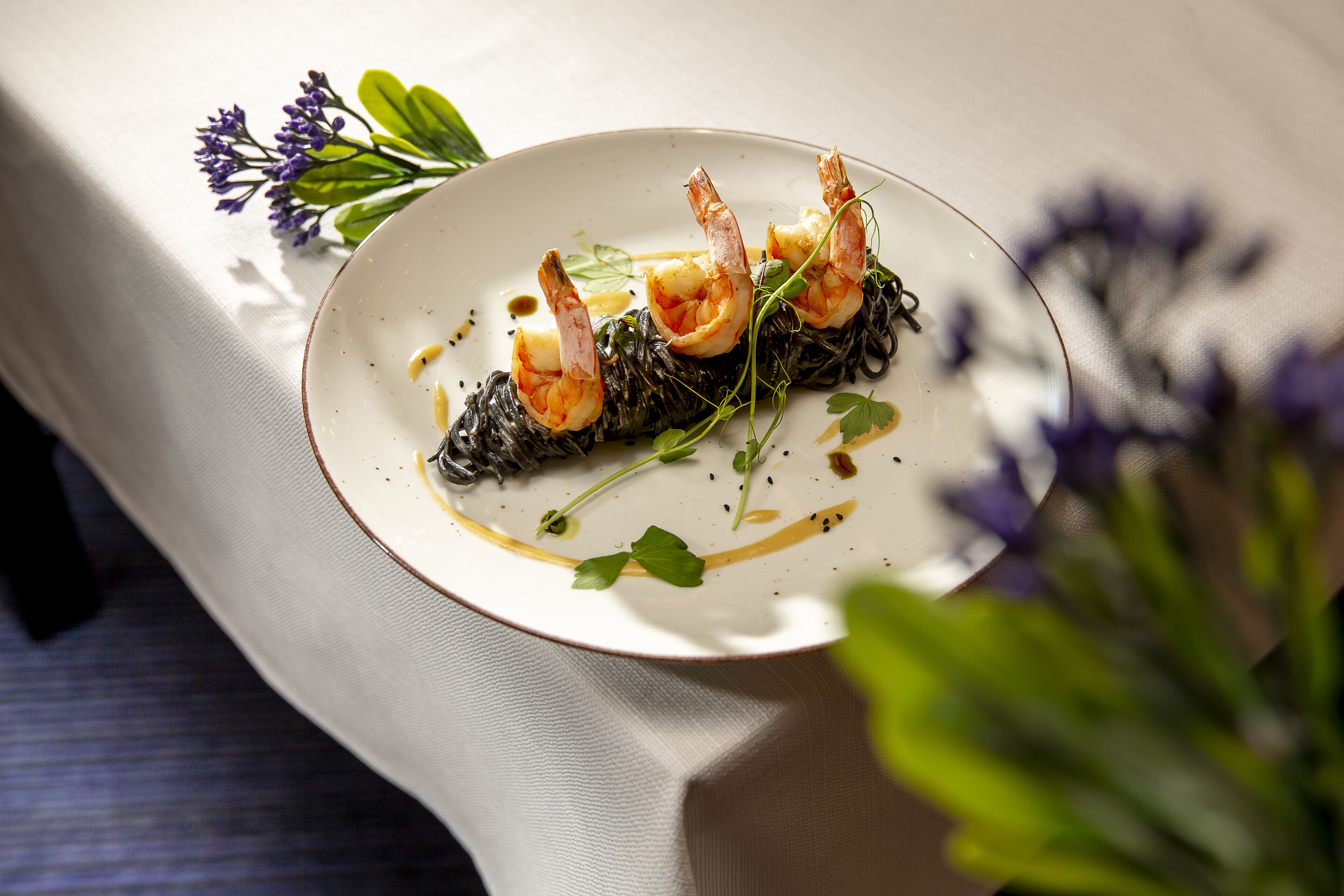 A plate of food with shrimp and greens on a white plate.