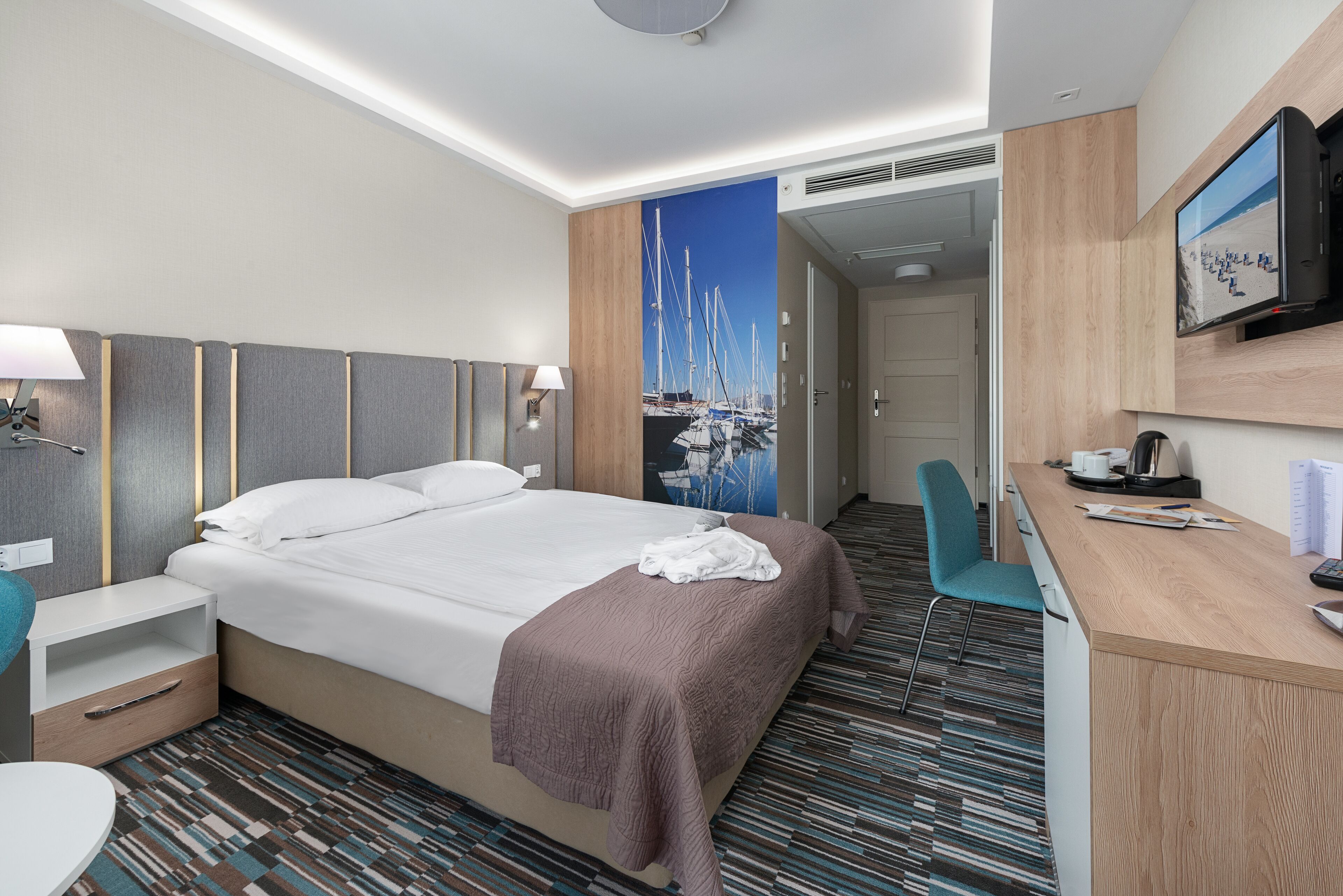 Une chambre d’hôtel comprenant un lit, un bureau, une chaise, une télévision et une salle de bain.