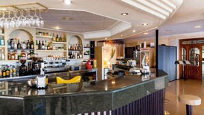 Un área de bar moderna con una barra curva, estantes llenos de botellas de licor y una máquina de café.
