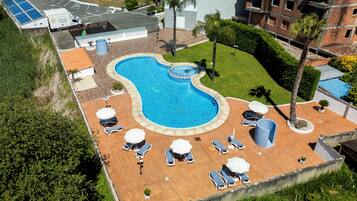 Una piscina al aire libre de temporada, sombrillas, tumbonas