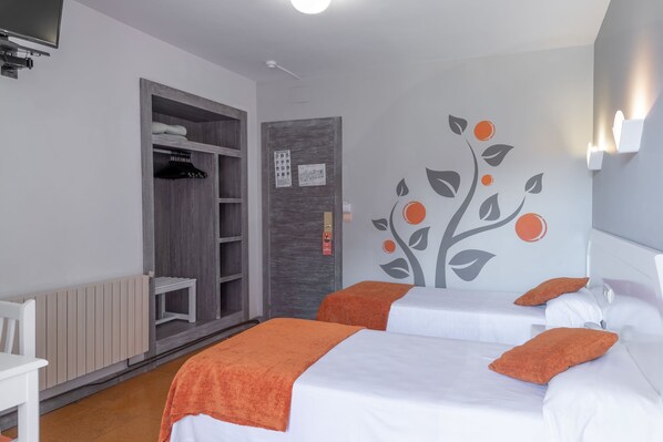 A hotel room with two beds, an open wardrobe, a wall mural, and a small table. - Hotel Los Naranjos (Sanxenxo)