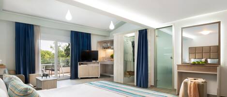 Habitación de hotel moderna con una cama grande, un escritorio, un televisor y un balcón con vistas.