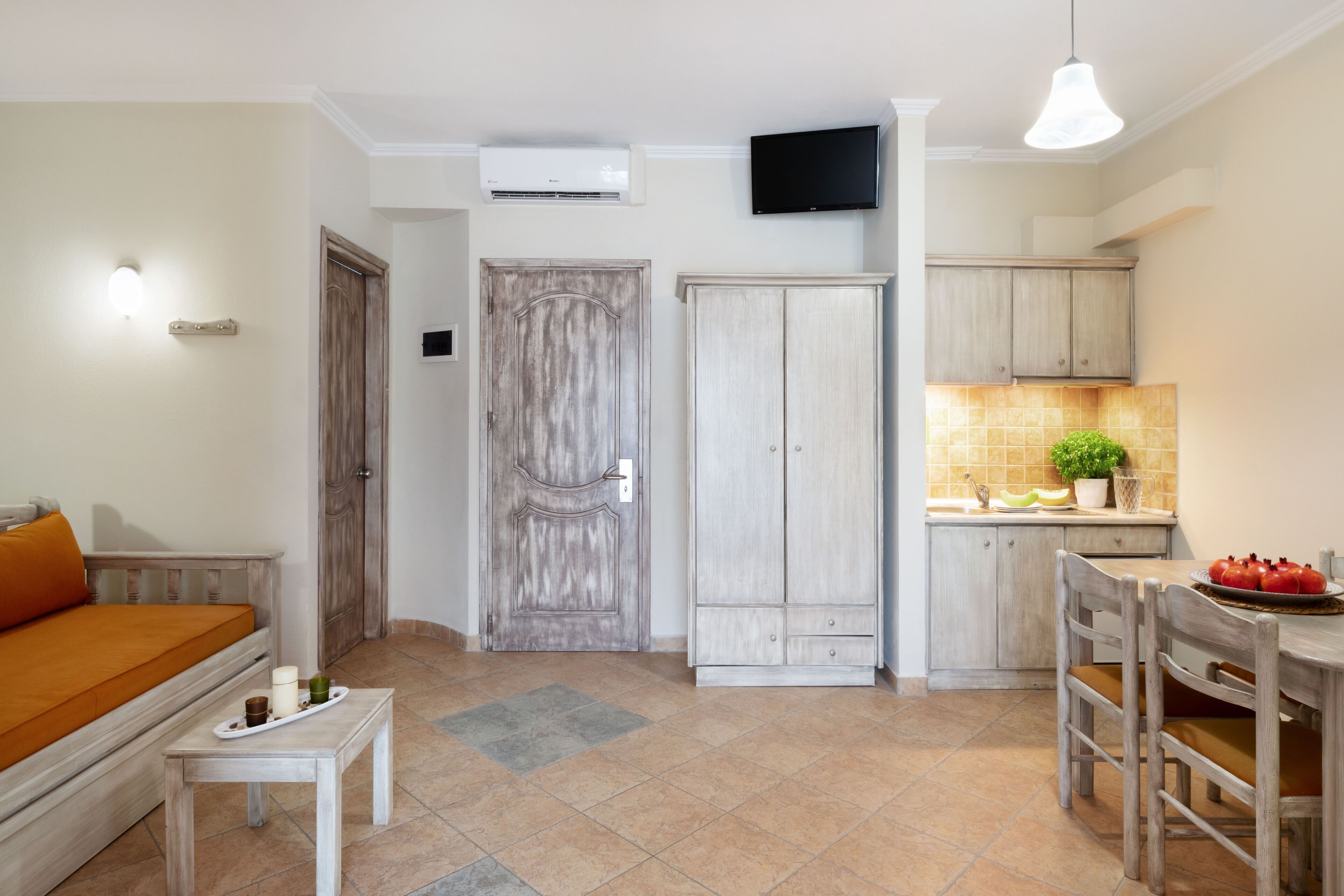 A compact living space with a sofa, a dining table, and a kitchen area.