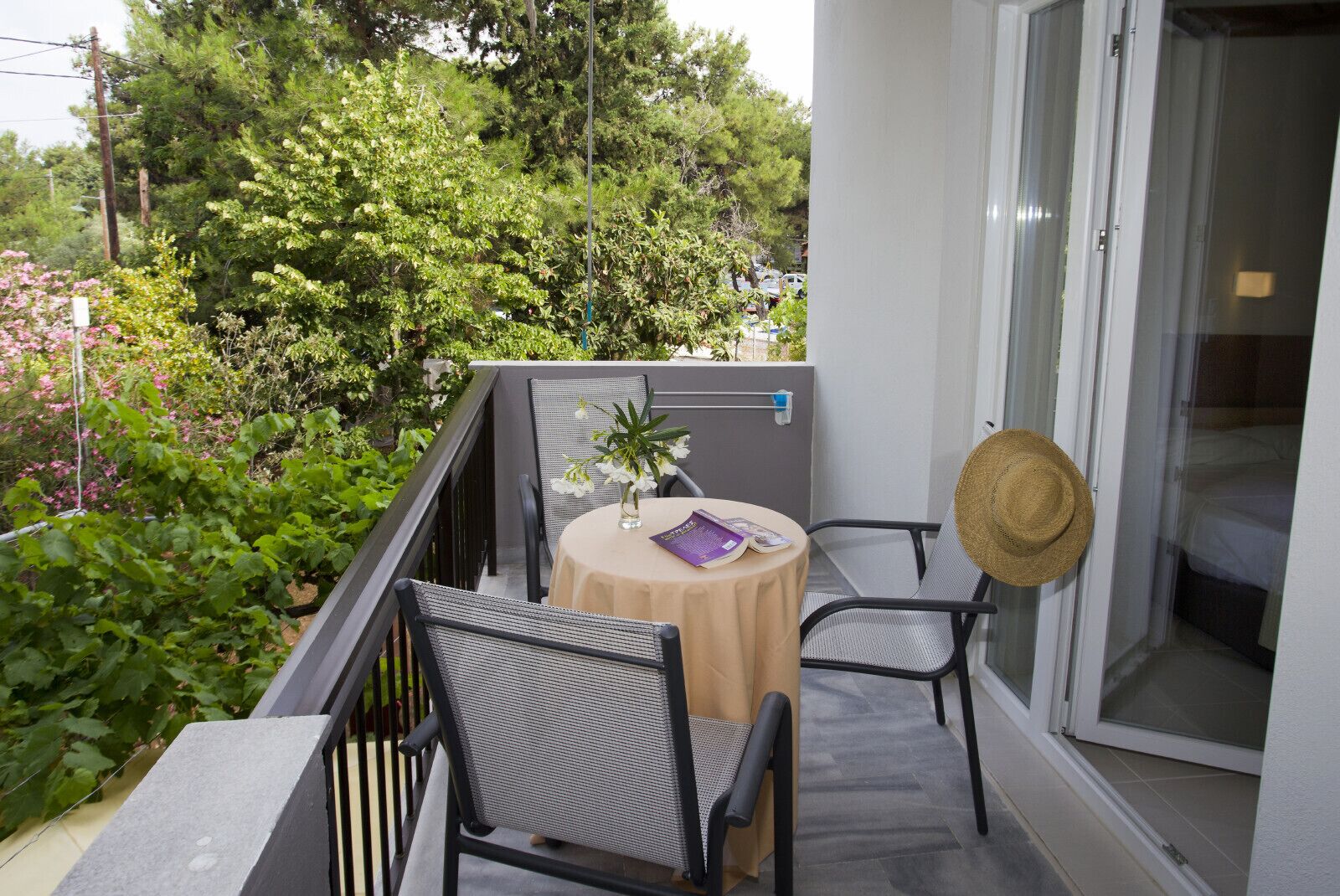 A balcony with two chairs, a table, and a potted plant.