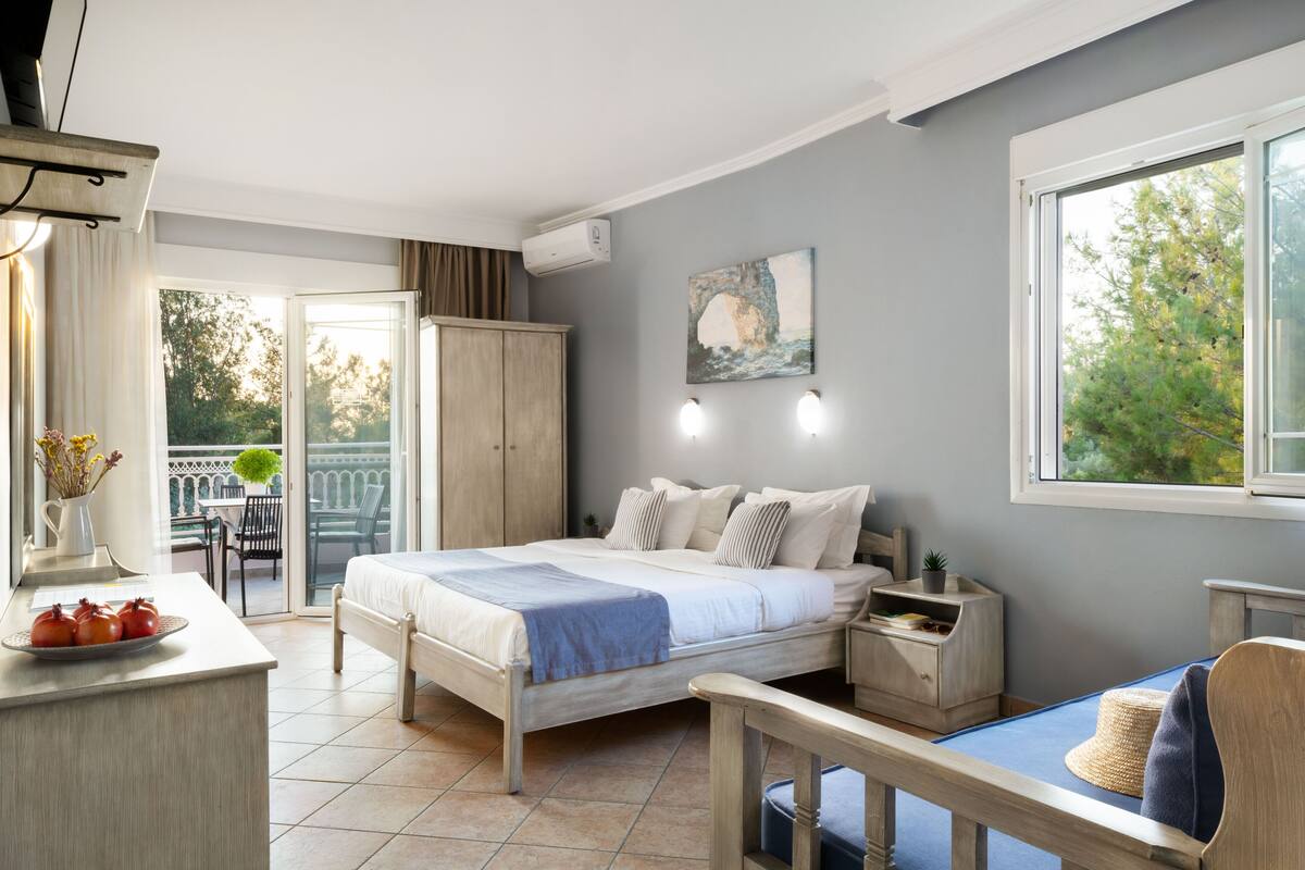 Une chambre à coucher avec un lit, une table de chevet et une vue sur l’extérieur.