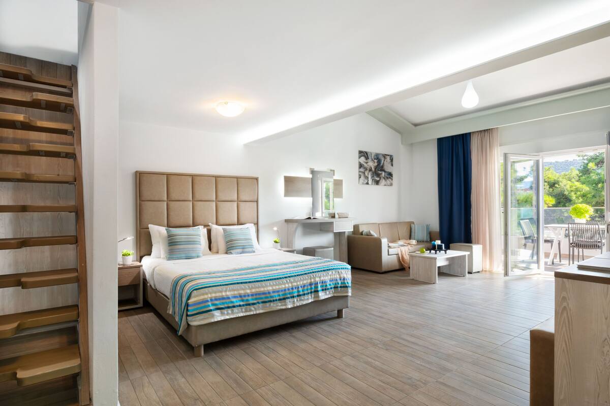 Une chambre d’hôtel moderne dotée d’un grand lit, d’un bureau, d’une chaise et d’un balcon avec vue.