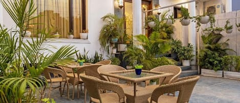 A patio area with wicker furniture and potted plants.