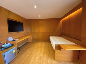 A room with a bed, a small desk, a television, and a refrigerator. - Big Tree Old Town Hotel (Chiang Mai)