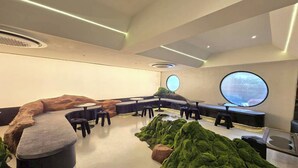 A modern interior with round tables, a central seating area, and a large window. - Big Tree Old Town Hotel (Chiang Mai)