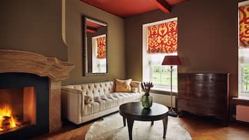 A living room with a fireplace, a sofa, a coffee table, and a dresser.