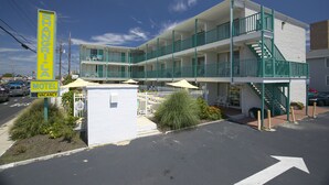 A motel with a two-story structure, a balcony on the upper floor, and a staircase leading to the entrance. - The Shangri La Motel (Ocean City)