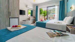 Habitación de hotel con dos camas, televisión, kitchenette pequeña y balcón con vistas.