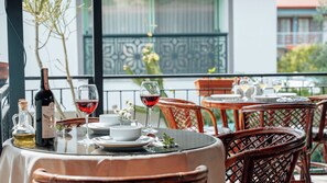 A dining area with tables, chairs, and a bottle of wine. - Flower Pension Hotel (Kas)