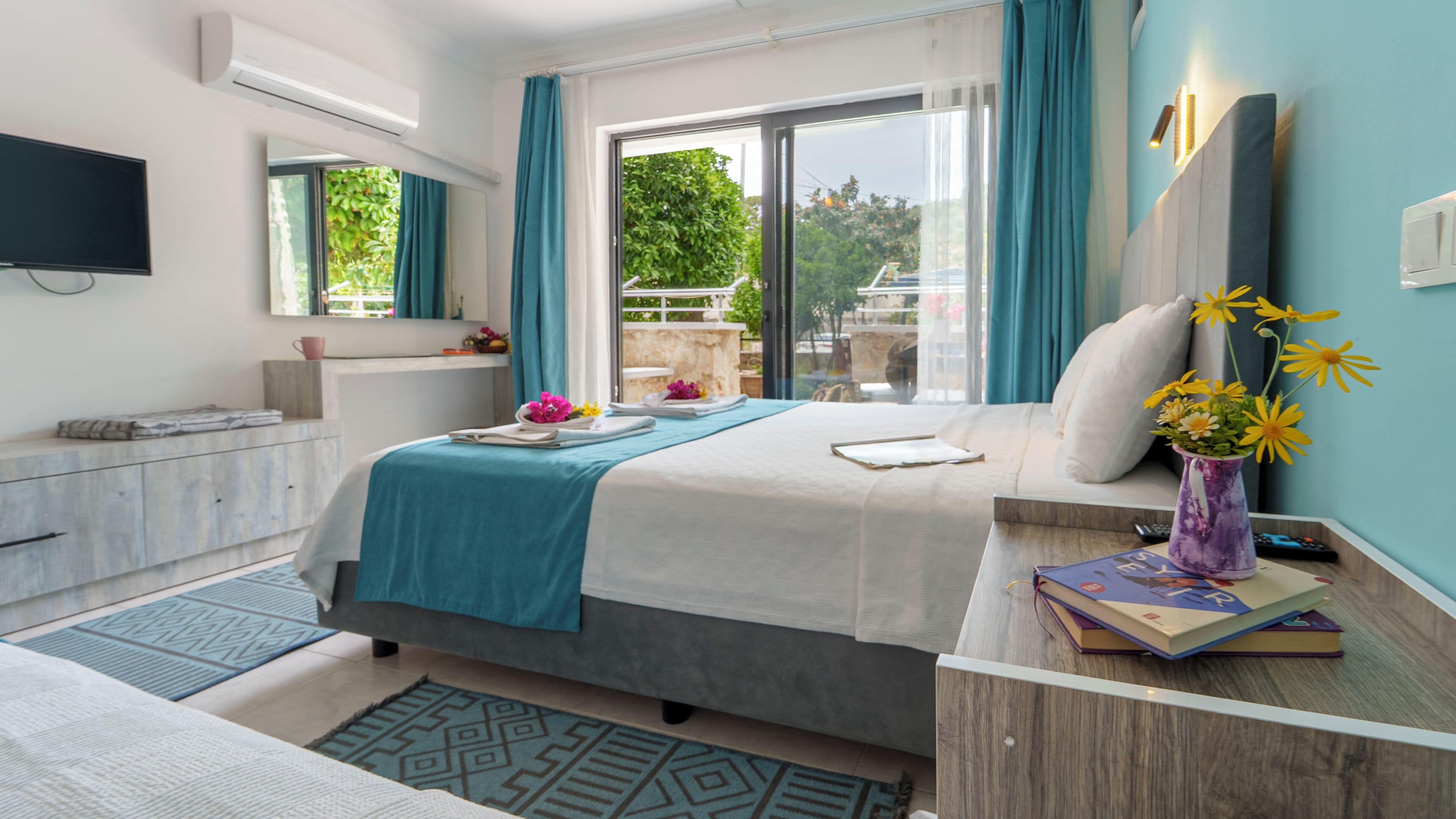 Habitación de hotel moderna con una cama, mesita de noche y vistas a zonas verdes.