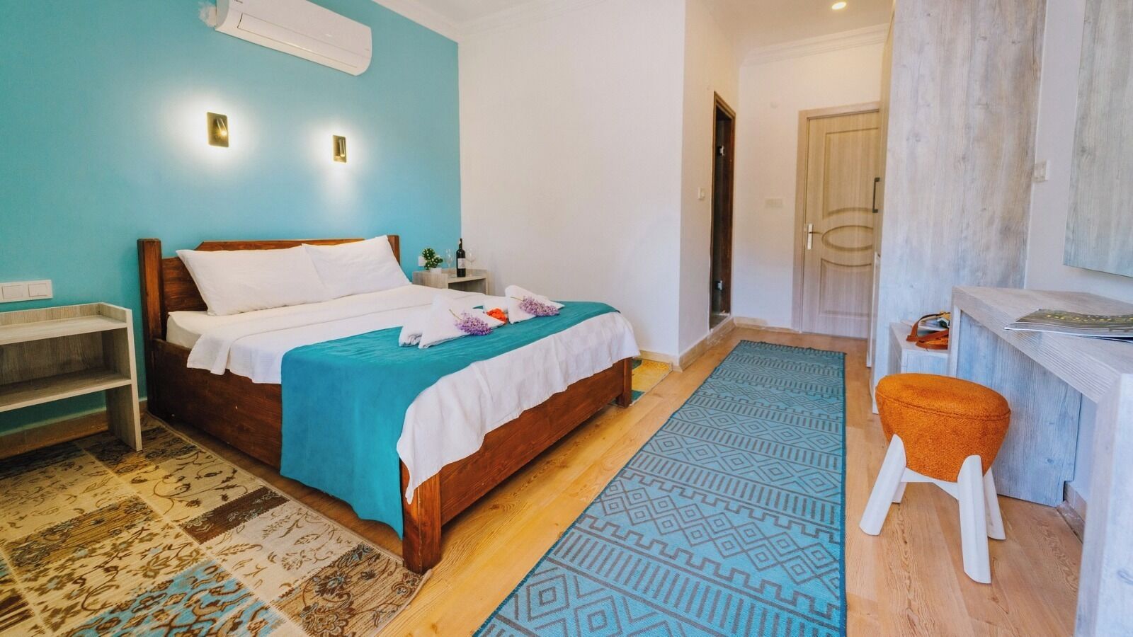Quarto com cama, mesa de cabeceira, cadeira e escrivaninha.