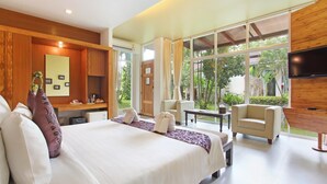 A modern hotel room with a large bed, a desk, a chair, and a TV.