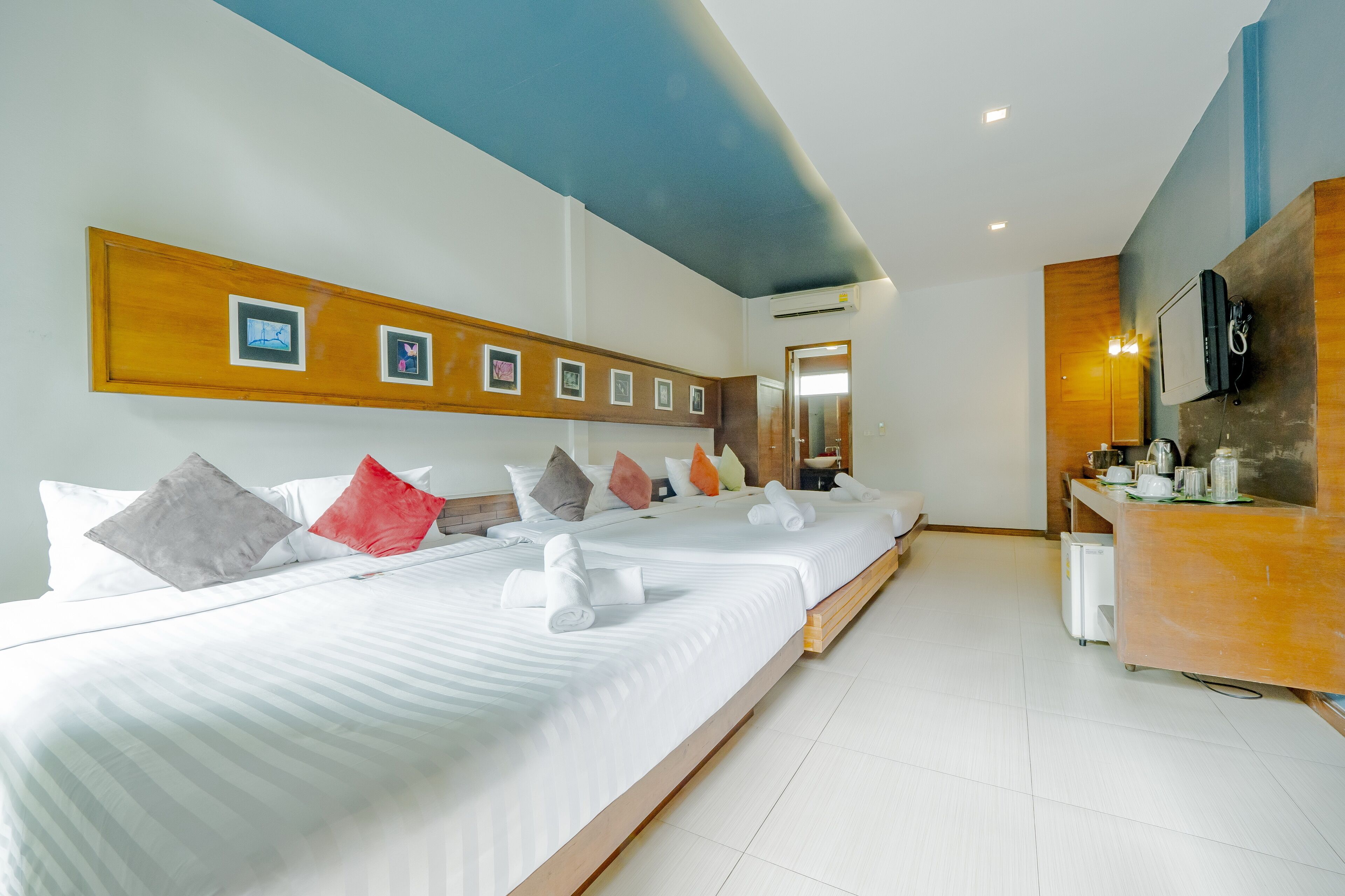 Una habitación de hotel con una cama grande, un cabecero de madera, un escritorio pequeño y un espejo.